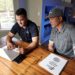 Two i9 Sports franchisees sit at a table in their home while working on a laptop.