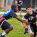 Two boys are playing flag football.