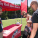 Parents, along with their son, talk with an i9 Sports member at a game.