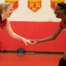 Girls are laughing while standing on the basketball court.