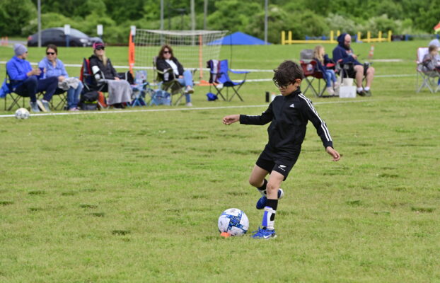 Young boy practicing his soccer dribbling skills at an i9 Sports Training Session.